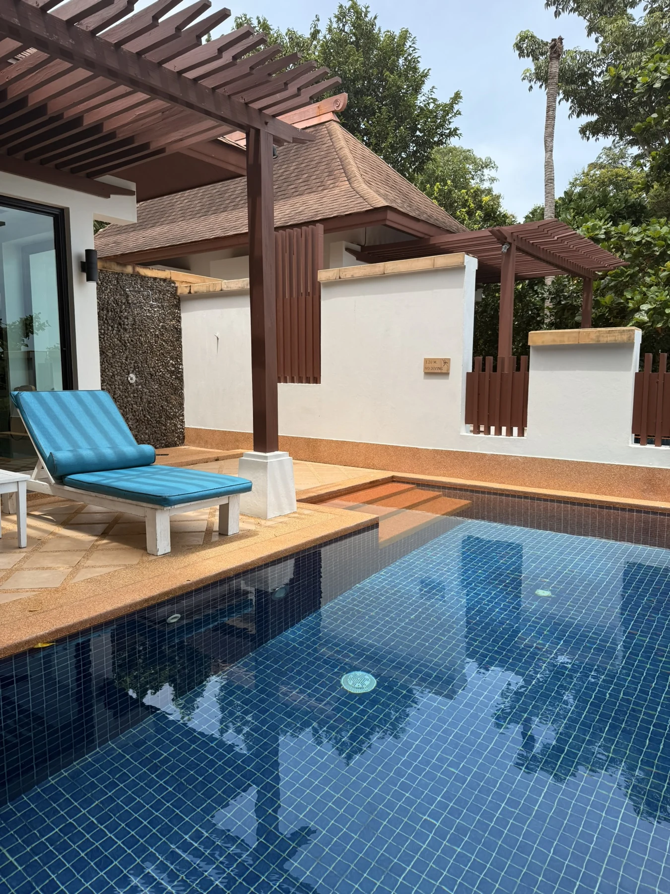 A pool and shaded outdoor seating area outside the room.