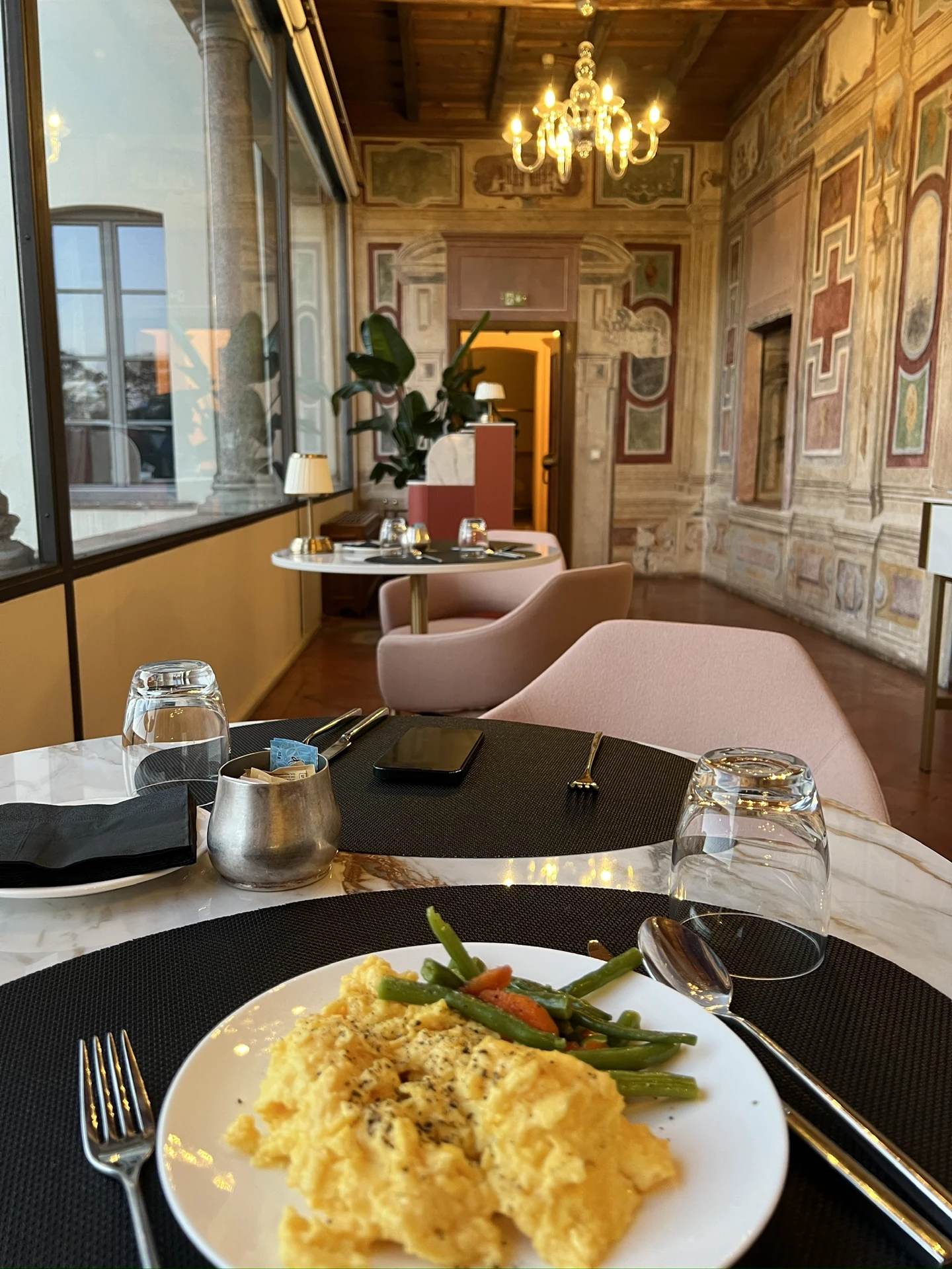 Breakfast at Villa Toretta in a dining space with painted walls and a chandelier.