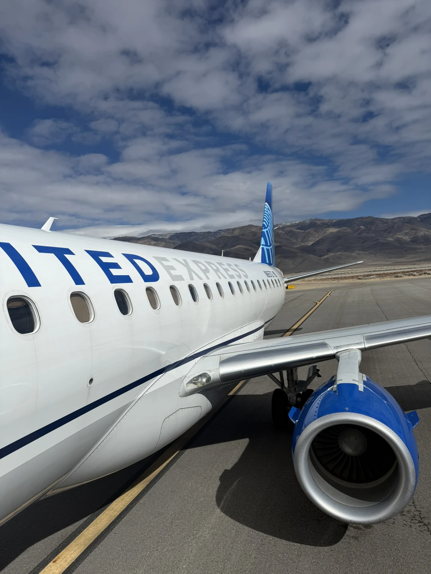 United Express aircraft at Bishop Airport in California, with mountains behind the apron.