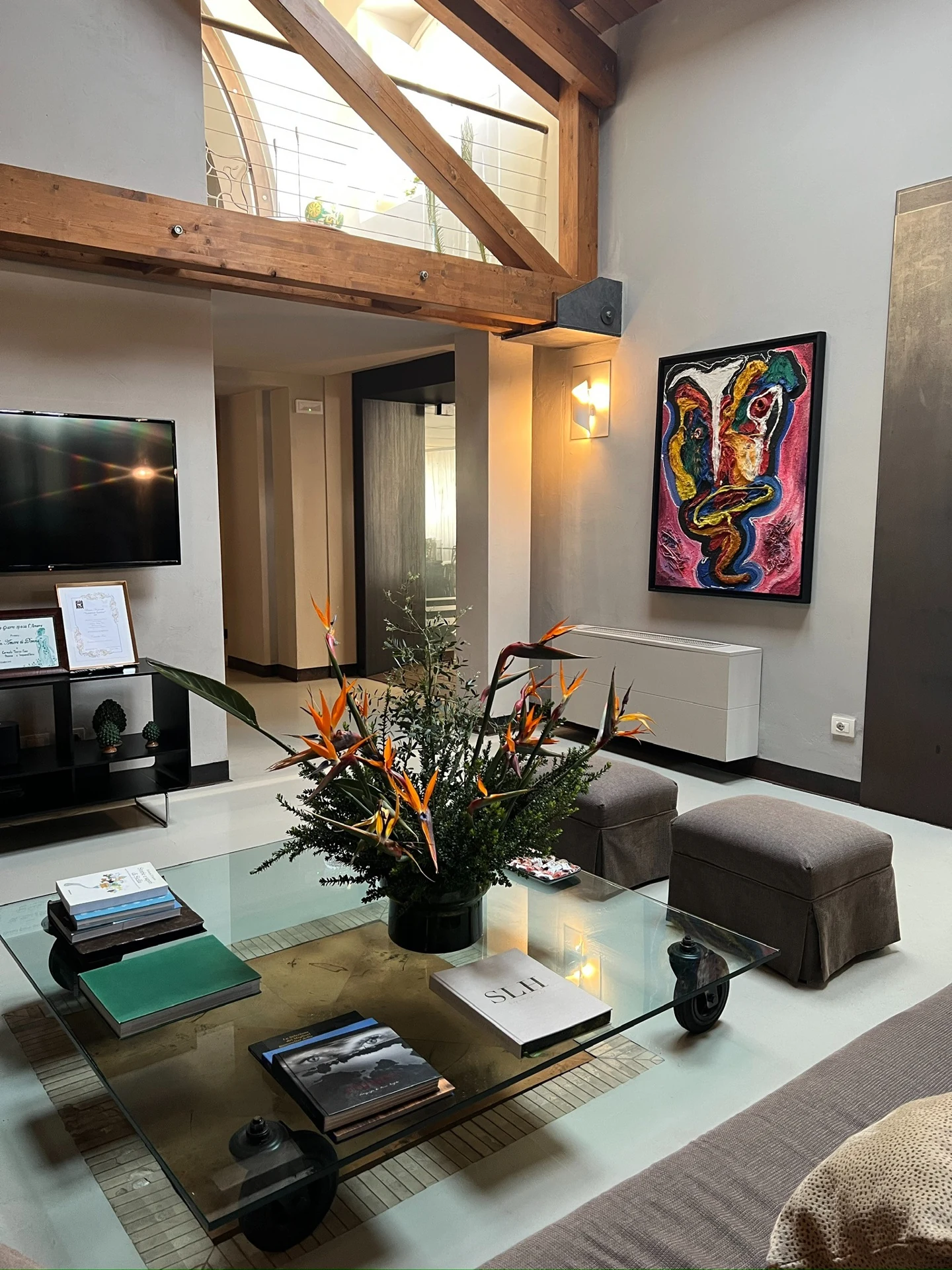 A sitting area at Donna Carmela Resort & Lodges with exposed timber beams and colorful artwork.