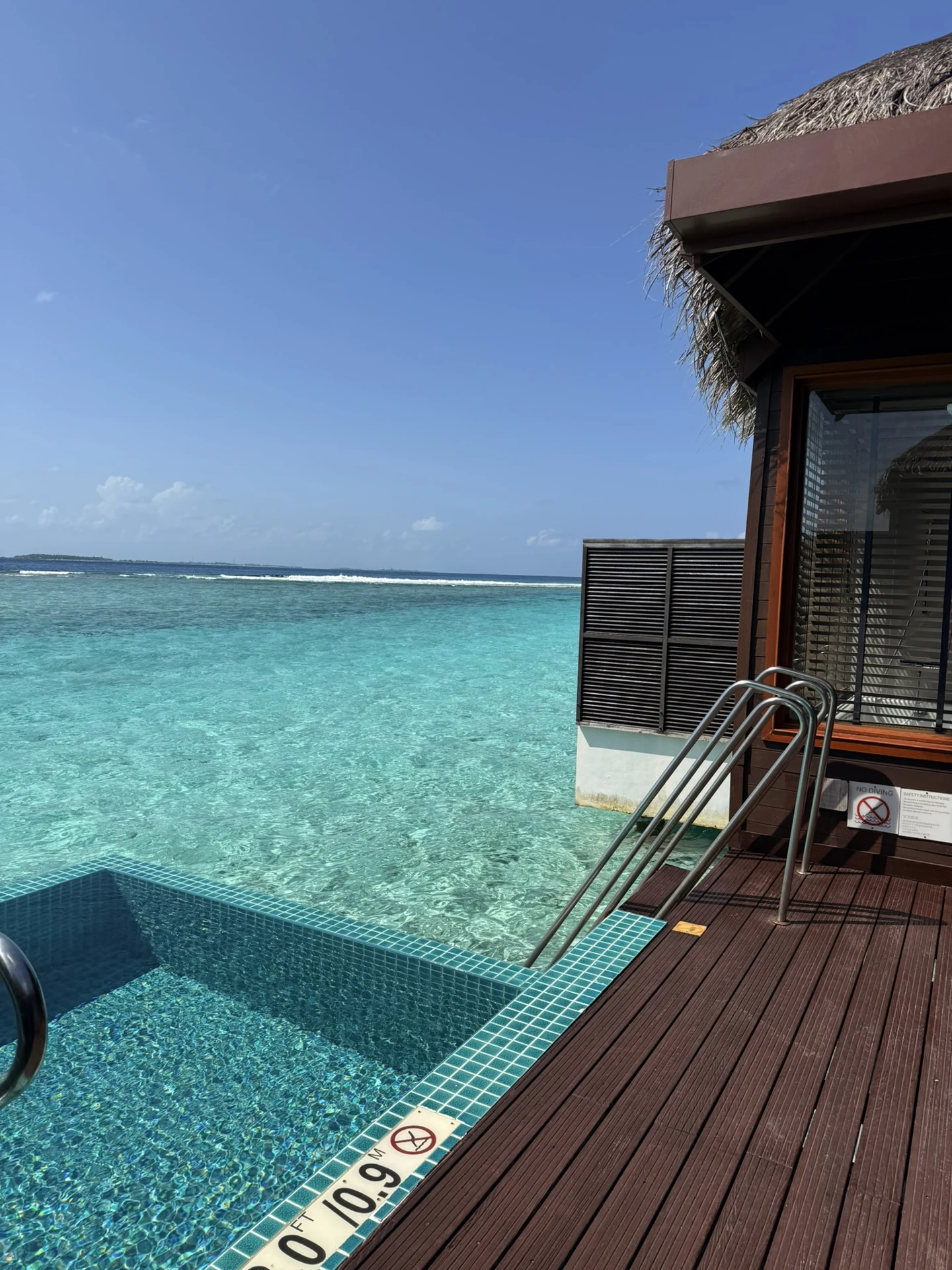 Pool and wooden deck overlooking the turquoise lagoon from my complimentary overwater villa upgrade at Sheraton Maldives Full Moon Resort & Spa.