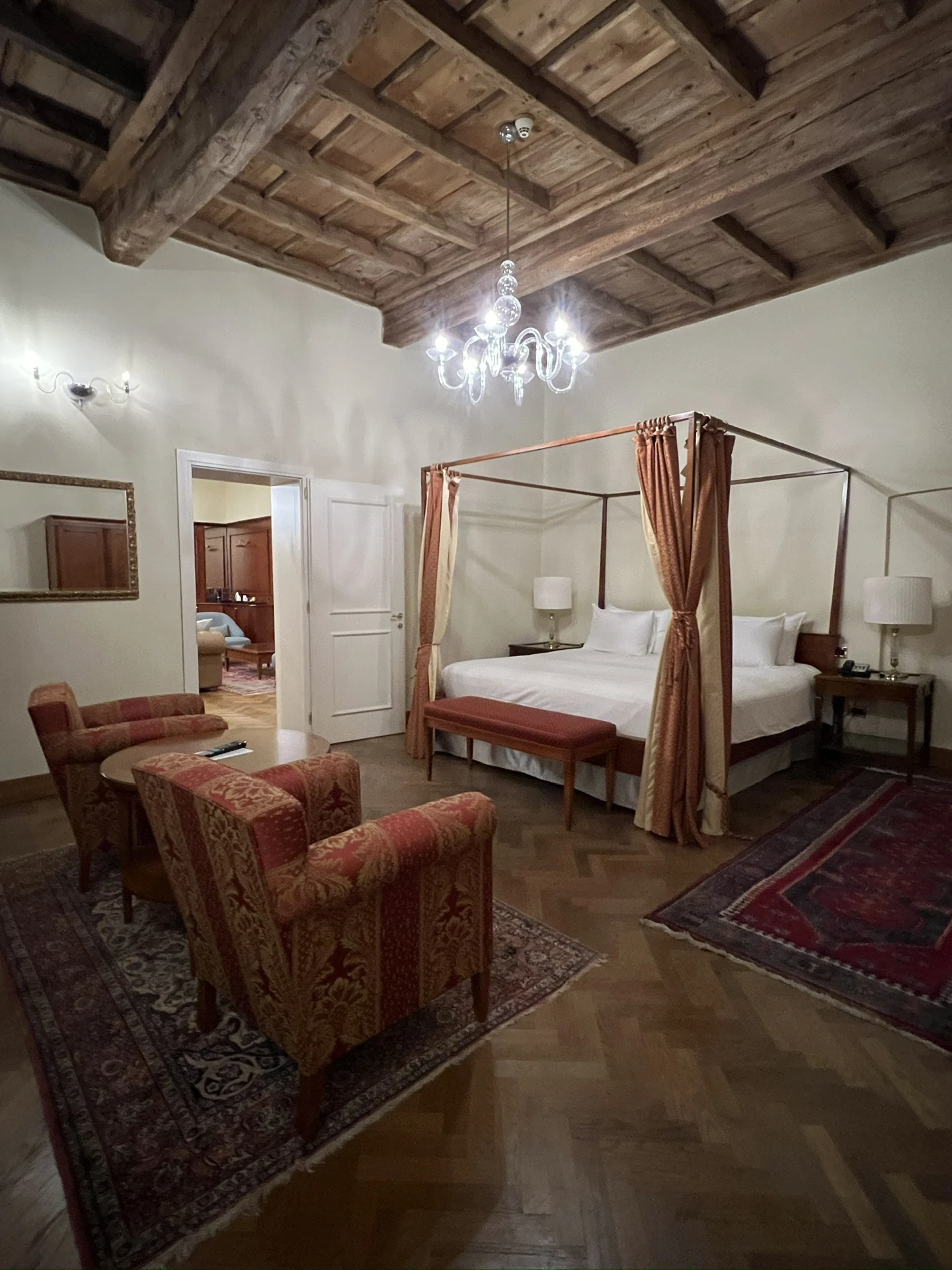 The Presidential Suite bedroom at Villa Toretta, with a four-poster bed and exposed wooden ceiling.