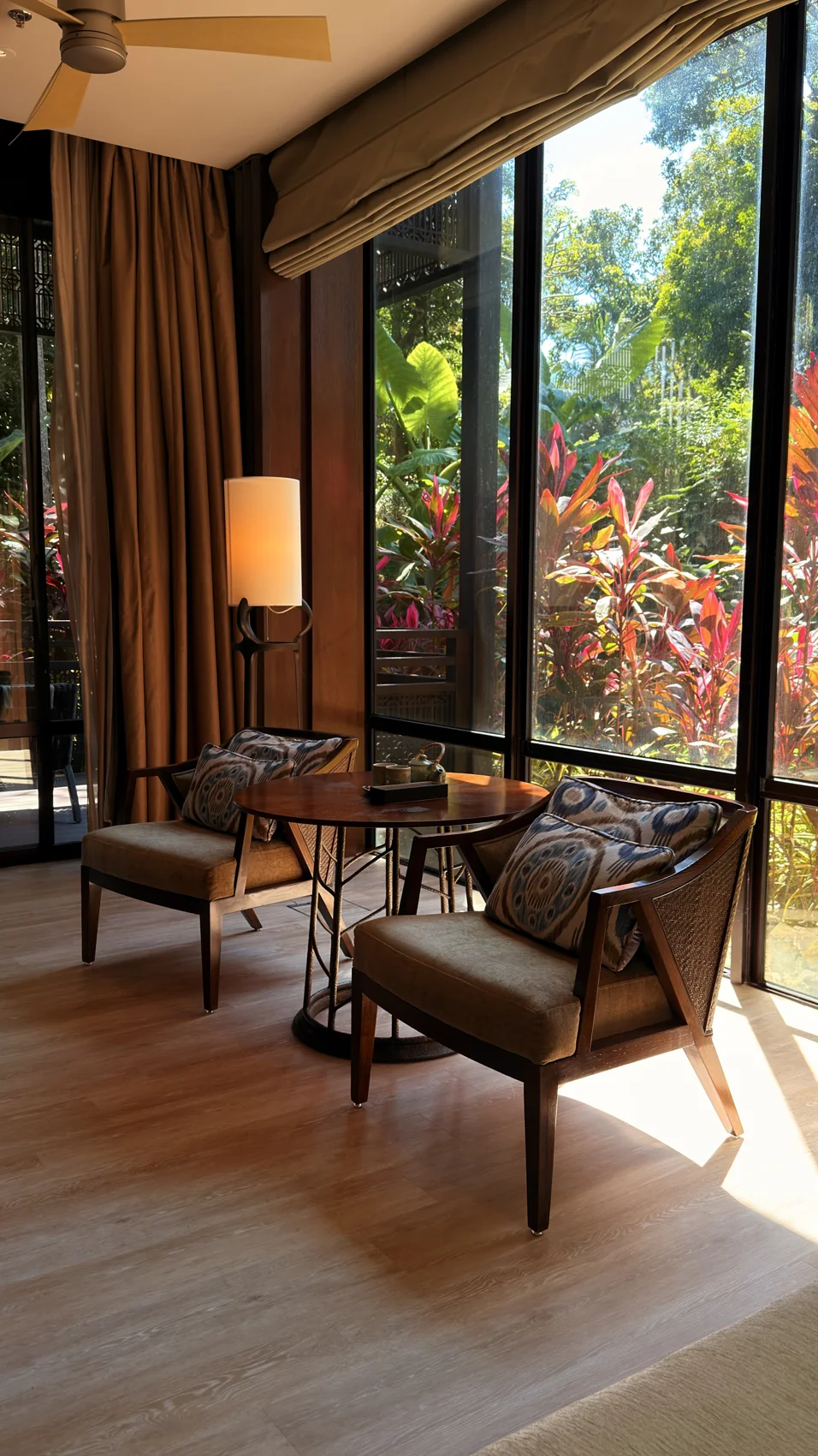 Kerusi dan meja di tepi tingkap besar dalam suite Ritz-Carlton.