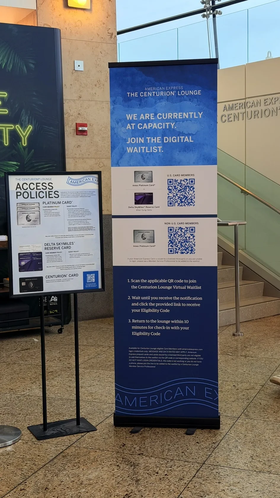 Centurion Lounge entrance signage in Seattle showing access information and QR codes.