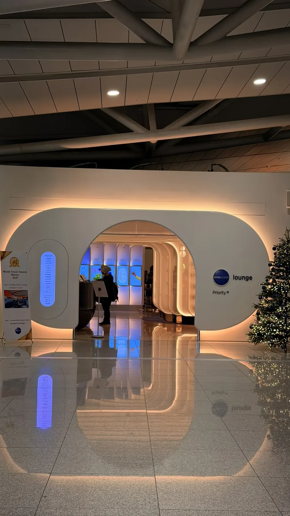 Curved entrance and illuminated seating at the oneworld Lounge in Seoul Incheon.