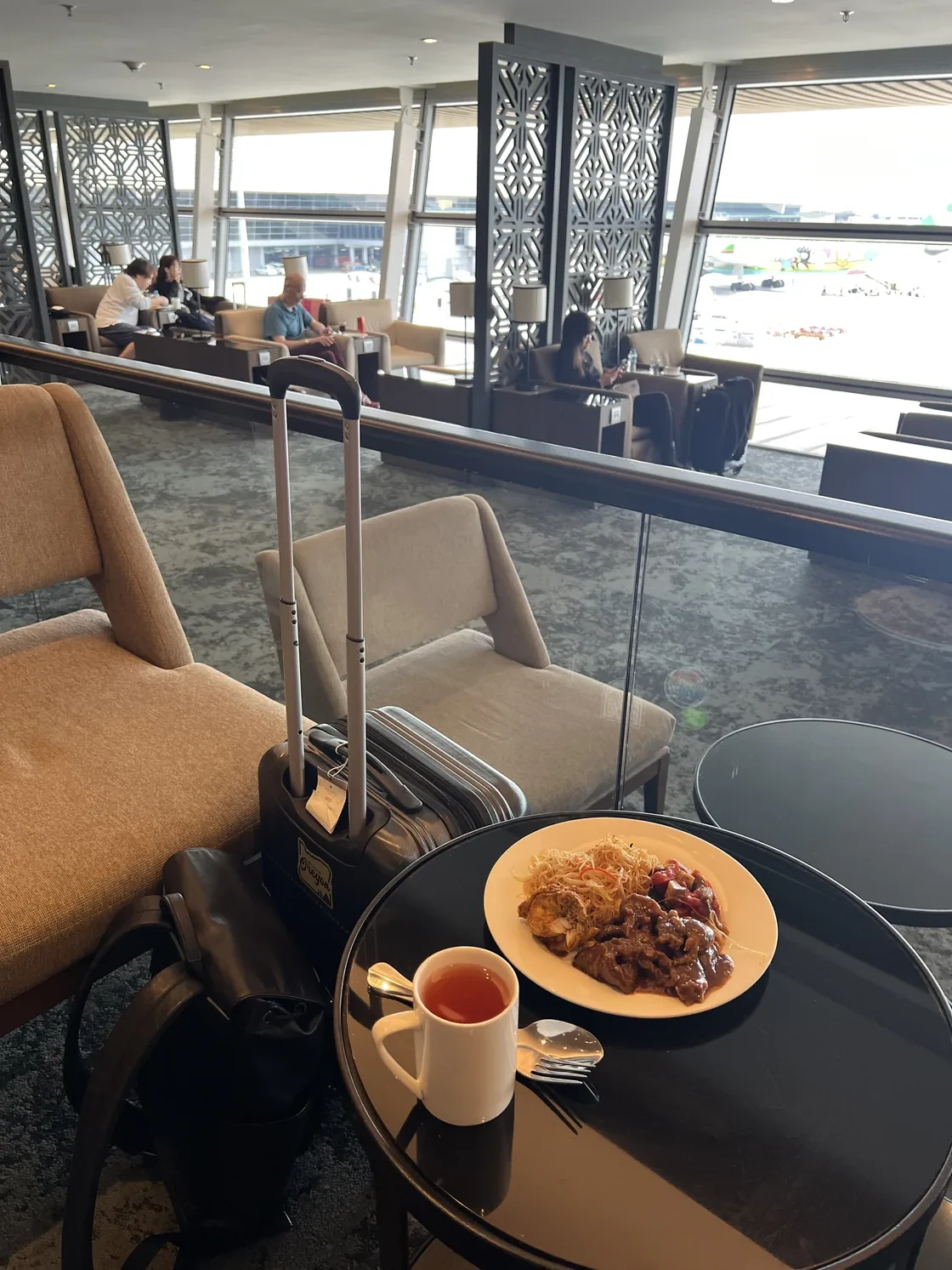 Breakfast, lounge seating, and an apron view at Malaysia Airlines’ Golden Lounge in Kuala Lumpur.